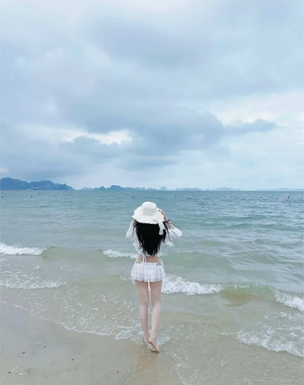 anh-gai-di-bien-che-mat-7 Cô gái thả bước ở mép nước, mũ rộng vành che nửa mặt, dáng nhỏ nhắn thanh thoát.